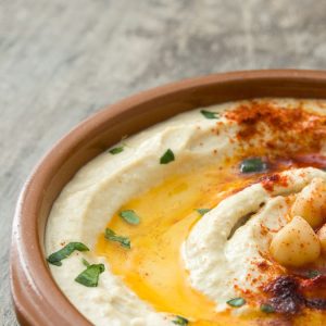 Hummus e mousse di legumi in ciotole rustiche con erbe fresche e spezie servite su sfondo naturale. Ricetta antispreco estiva della Ciociaria | Hummus e mousse speziate: l’anima cremosa dei legumi Hummus e mousse speziate: l’anima cremosa dei legumi